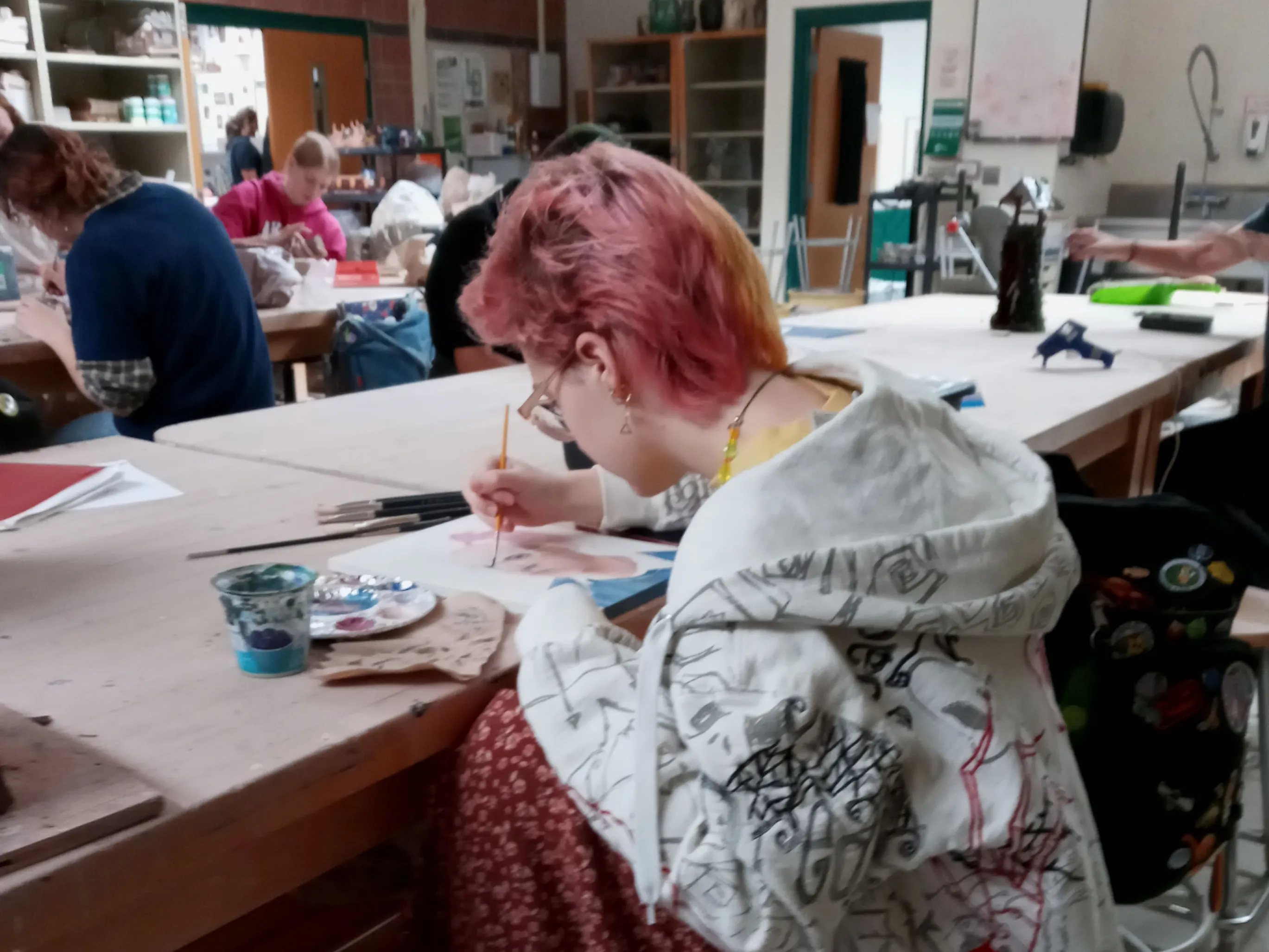 A person painting in an art classroom